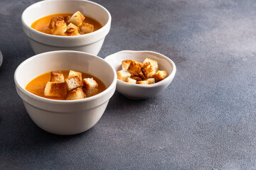 Butternut squash soup with bread croutons in  ceramic bowl