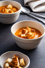Butternut squash soup with bread croutons in  ceramic bowl