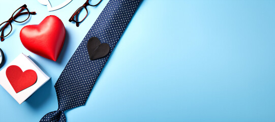 Composition of stylish necktie, watch, gift box, glasses, mustaches, and paper hearts, framed in heart cutout on soft blue background.