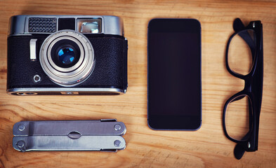 Above, smartphone and camera on table for photography, hobby and equipment with glasses. Technology, multi tool and retro gear for creative, production and wooden table for picture or film items