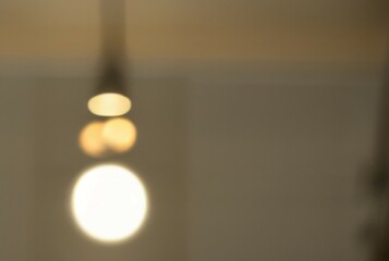 Soft light fixture glow. Blurred pendant lamp, warm lighting evokes calmness and serenity.  Home interior design element.