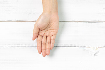 Single Open Hand Facing Upwards on White Wooden Background