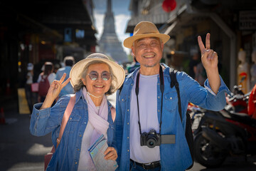 Obraz premium Asian retired couple happily hang out together in city full people city full buildings in capital Thailand Bangkok