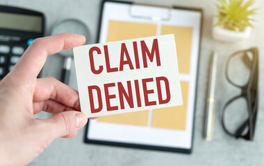 Business woman holding a card with text Claim Denied, business concept