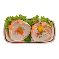 A beautifully arranged platter featuring two halved seafood shells filled with garnishes, egg, and colorful toppings on a bed of fresh lettuce.