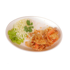 A plate featuring crispy fried food accompanied by fresh lettuce, shredded cabbage, and garnished with herbs.