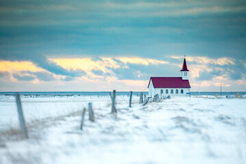 Church with red roof in winter landscape in Iceland.