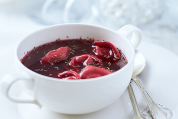 Traditional Christmas Borscht (Barszcz) with mushroom dumplings on bright background.