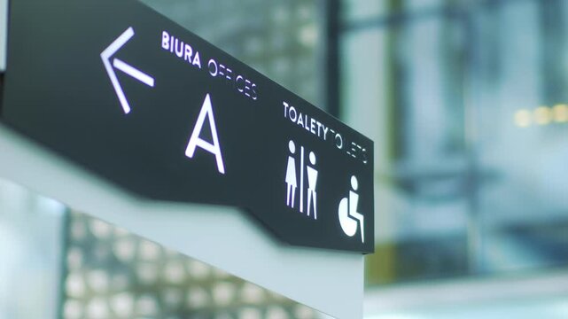 A sleek office sign with directions and icons, guiding employees and visitors in a modern corporate space, displayed in crisp 4K slow motion 60fps
