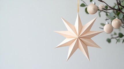 Obraz premium Elegant paper star ornament hangs gracefully on a branch surrounded by simple geometric decorations