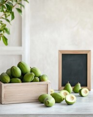 Fresh green Feijoa in wooden crate next to blackboard in minimalist kitchen setting