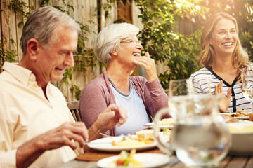 Senior parents, laughing and smile with woman, lunch together and home backyard for family. Thanksgiving, celebration and mother with child on holiday, vacation and event for tradition and bonding