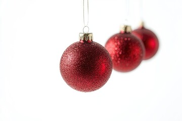 Three red glass ornaments hang from a string, ready for holiday decorating