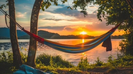A vibrant hammock hangs between trees by a serene lake during sunset, creating a peaceful retreat, Ideal for travel blogs, relaxation themes, or nature retreats promoting leisure and tranquility,
