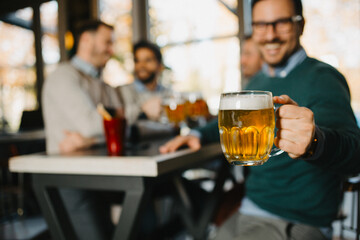 Man holding beer glass in pub