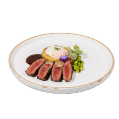 A beautifully plated dish featuring sliced steak, a poached egg, and garnishes, creating an elegant presentation.