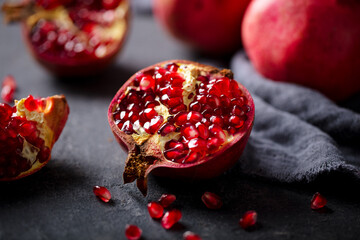 Fresh pomegranate on stone table. Grey background. Close up.