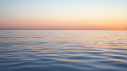 Fototapeta premium A serene view of calm ocean waters at sunset, showcasing soft waves and a gradient sky.