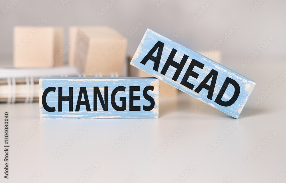 Poster changes ahead text on a wooden block with notebook, business concept.
