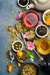 A set of aromatic tea: black, green, herbal and flower tea. On a gray stone table.