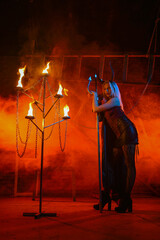 Fototapeta premium A beautiful woman with devilish horns on a red blood like smoky hell concept background.