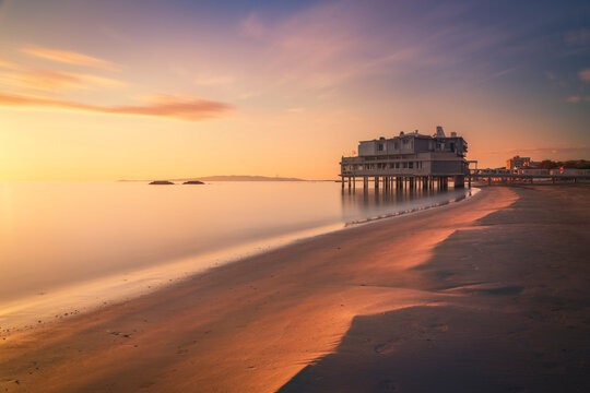 Follonica beach and shoreline with building on the sea at sunset. Tuscany, Italy