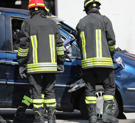 Teams of Firefighters use powerful hydraulic shears to rip off the doors of a damaged car freeing...