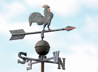 Old vintage weathercock with cock  rooster of iron to measuring the direction of wind