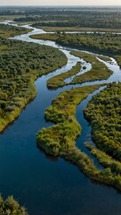 Naklejka premium Aerial view of a blue river near a village and wetlands.