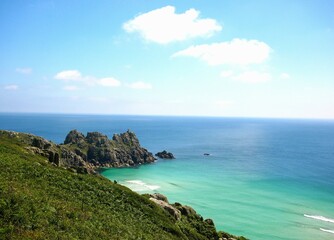 Fototapeta premium Picturesque headland overlooking open ocean with small private beach in Cornwall, England