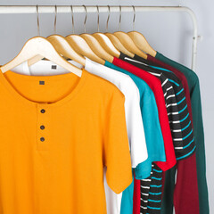 Obraz premium various types and colors of t-shirt collections hung in a row with orange on the front