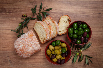 a mixture of olives, varieties of Halkidiki, Verdi giganti and Kalamata, in a bowl, with sliced...