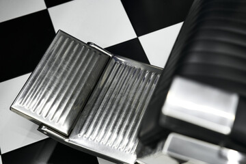 Shiny chrome barber chair footrest in modern barbershop interior design