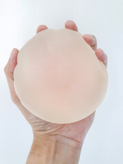 Breast silicone implants surgery with silicone, hand holding rough silicone breast augmentation,...