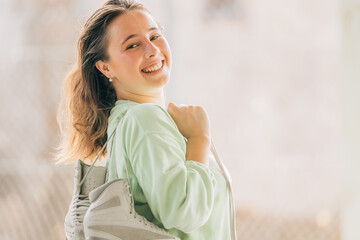 figure skating athlete with skates smiling outdoors