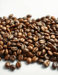 Freshly roasted coffee beans spread across a white surface creating a rich and inviting texture for coffee lovers