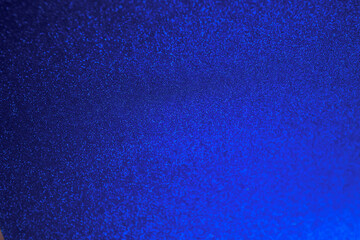 Bright Blue Glitter Texture Background. Abstract close-up of a bright blue glittery texture,...