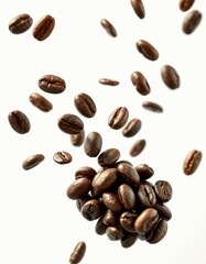 Freshly roasted coffee beans scattered above a heap of beans on a neutral background in a creative view