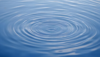 Fototapeta premium Closeup of water surface with ripples and reflections, against a blurred blue sky background