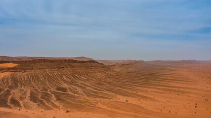 Moroccan Sahara Desert, ancient black volcanic mountains, the Sahara River Oued Ghris, stunning Acacia trees, wild camels, and desert camp,  landscape where golden sand dunes merge with green plants