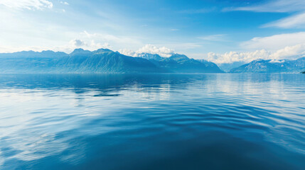 Serene Waters of a Lake Surrounded by Majestic Mountains Under Sky