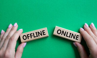 Offline or Online symbol. Concept word Offline or Online on wooden blocks. Businessman hand. Beautiful green background. Business and Offline or Online concept. Copy space