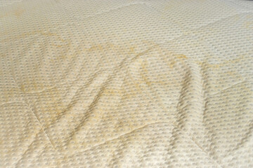 A dirty mattress with yellow stains. Cleaning textile at home concept