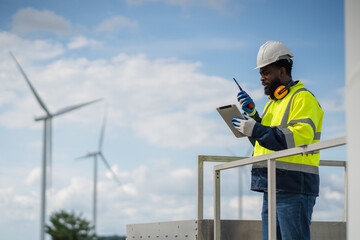 Service engineers checking system of windmill. Wind turbines generate electricity. Clean and Renewable energy concept.