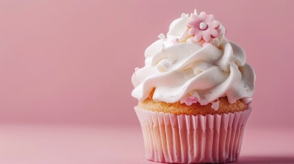 Pink cupcake topped with flower-shaped white whipped cream on a pink backdrop. Ideal for a menu or bakery brochure.