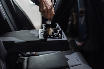 man washes and cleans with a brush the car interior. Detailing