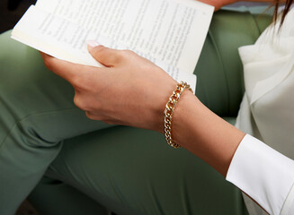 Gold chain bracelet on young woman hand