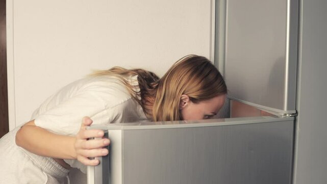 Woman open refrigerator door, searching for food. Frustration builds as she looks for something specific in an empty fridge, highlighting challenges of meal planning