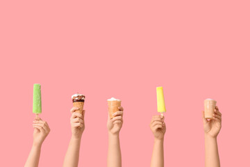 Female hands with different sweet ice-cream on pink background