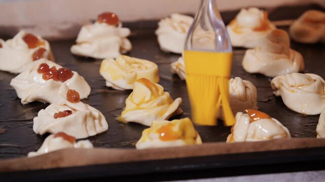 Preparing cruffins with egg wash and toppings for baking on a baking sheet